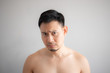 © Sevendeman - Cry and sad face of Asian man in topless portrait isolated on gray background.