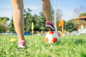 Young female soccer player traning with ball in the stadium - Sporty woman making exercises on the train field - Concept of sportive people lifestyle