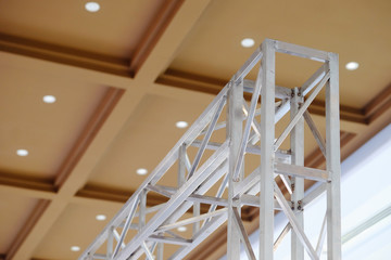 Top corner of white metal wireframe indoor structure with background of ceiling in a room