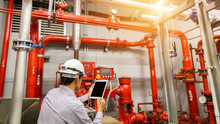 Engineer With Tablet Check Red Generator Pump For Water Sprinkler Piping And Fire Alarm Control System.