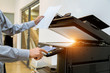 © A Stockphoto - Business man Hand press button on panel of printer, printer scanner laser office copy machine supplies start