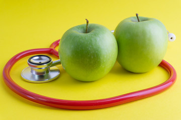 Wall Mural - Green Apple with medical stethoscope isolated on yellow background for healthy eating. Selective focus and crop fragment. Healthy, Diet and copy space concept