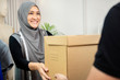 © Atstock Productions - Muslim woman designer receiving parcel box from delivery man