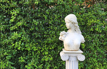Woman Statue In The Garden With Copy Space. Wall Leaf In Nature Park.