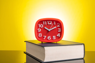 Wall Mural - Clock and book with yellow background