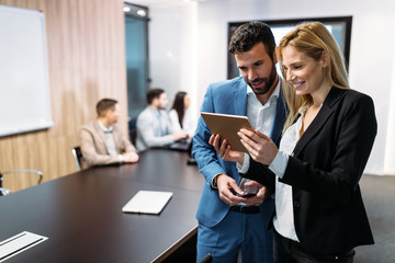 Businesspeople discussing while using digital tablet in office