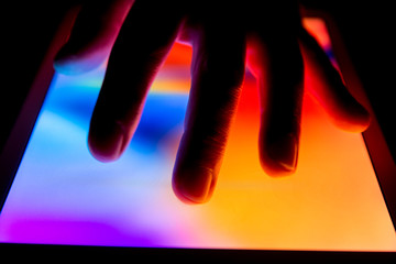 Hand using touch screen tablet business computer night