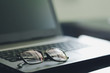 © zasabe - Black plastic eye glasses, placed on a portable computer On the desk, feeling lonely from work Concept of rest after hard work Completed work
