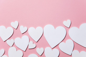 Wall Mural - White hearts on a pastel pink background. 