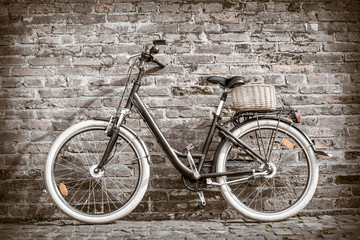 Black retro vintage bicycle with old brick wall.