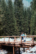 © Przemek Klos - Family walking across the wooden bridge in mountains