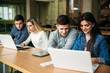 © Aleksandr - Group of college students studying in the school library, a girl and a boy are using a laptop and connecting to internet. Prepare for an exam