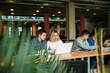 © Aleksandr - Group of college students studying in the school library, a girl and a boy are using a laptop and connecting to internet. Prepare for an exam