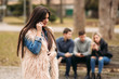 © Aleksandr - Young people having a good time in park. Male and female sitting on the bench and using phones
