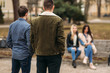 © Aleksandr - Young people having a good time in park. Male and female sitting on the bench and using phones