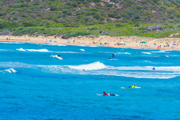 Wall Mural - Surfers in Porto Ferro beach on a summer day