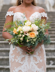 Wall Mural - the bride is holding a rustic wedding bouquet of flowers and various herbs