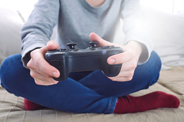 Sticker - man holding a joystick controllers while playing a video games at home