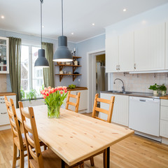 interior of a kitchen with orange tulips on the table