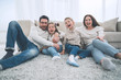 © ASDF - happy family sitting on the carpet in the living room.