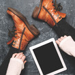 Female legs shod in Hiking boots and tablet pc. Mockup for text or apps