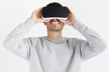 Handsome man playing video games in VR goggles or 3d glasses, wearing virtual reality headset