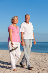 Wall Mural - Happy Senior Couple Walking Holding Hands on a Beach