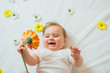 © kaloriya - Beautiful baby with a flower on white blanket