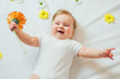 © kaloriya - Beautiful baby with a flower on white blanket