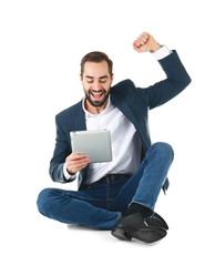 Emotional businessman in office wear with tablet celebrating victory on white background