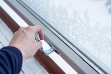 Hand Opening Lock Window With Ice Flake In Winter