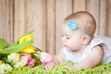 Wall Mural - Adorable baby girl with tulips