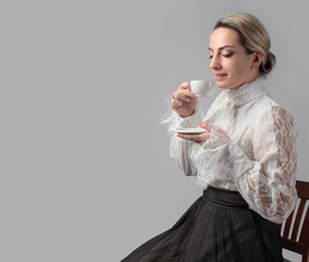 Wall Mural - Portrait of a woman in Victorian clothes with a cup of coffee.