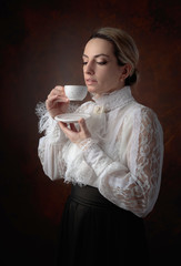 Wall Mural - Portrait of a woman in Victorian clothes with a cup of coffee.