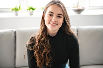 A teen girl relaxing on the sofa at home