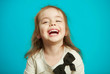 © Ilshat - cheerful little girl laughs on blue background.