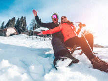 Happy Influencers Couple Having Fun With Wood Vintage Sledding On Snow High Mountains - Young Crazy People Enoying Winter Vacation - Travel And Holiday Concept