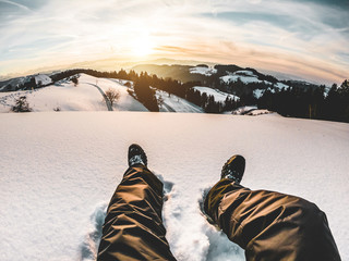 Pov view of young man looking the sunset on snow high mountains