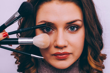 Makeup. Makeup brushes close-up. Model with make up on face