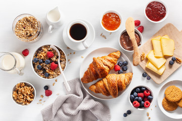 Wall Mural - healthy breakfast with granola, berry, nuts, croissant, jam, chocolate spread and coffee. Top view