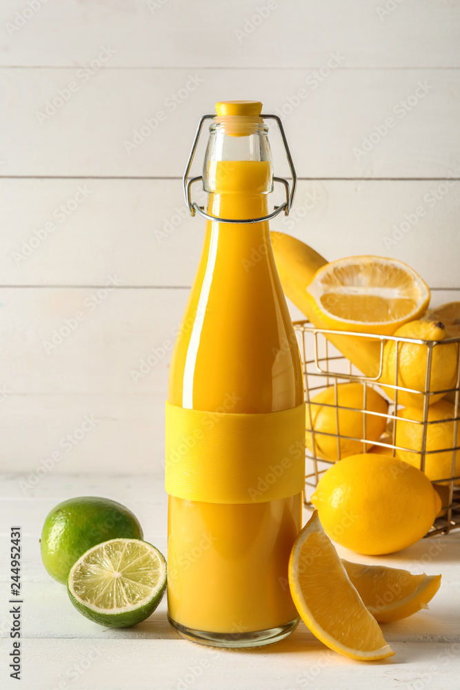 Bottle of healthy citrus juice on white table