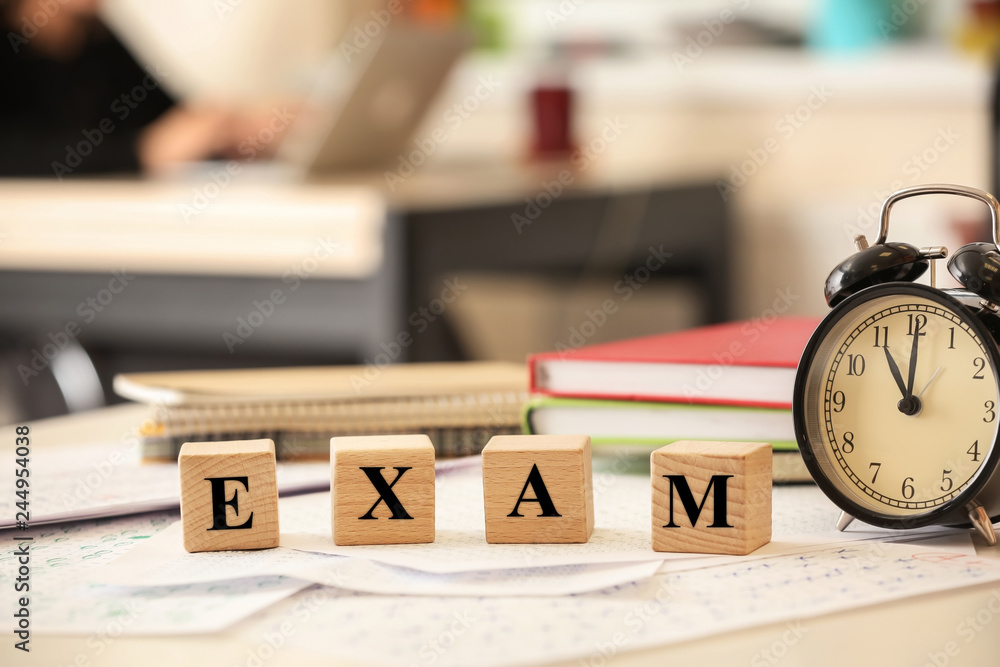Wooden cubes, stationery and clock on table. Concept of preparation for exam