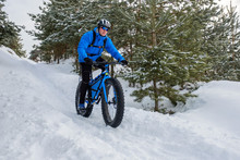 A Young Man Riding Fat Bicycle In The Winter
