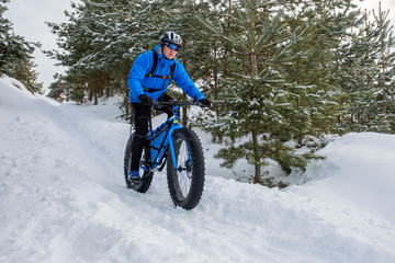 A young man riding fat bicycle in the winter