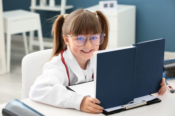 Sticker - Cute little girl dressed as doctor playing at home