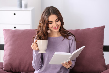 Sticker - Beautiful young woman drinking coffee while reading book at home