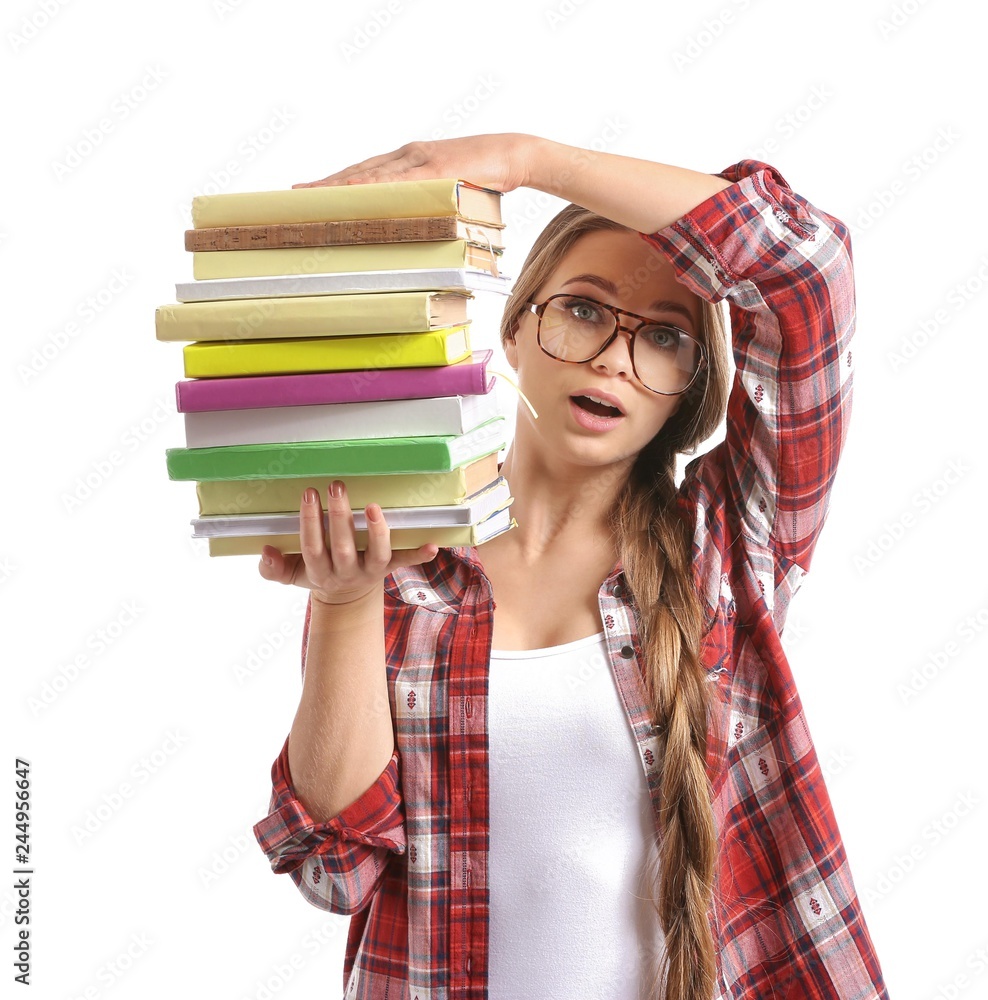 Beautiful young woman with stack of books on white background
