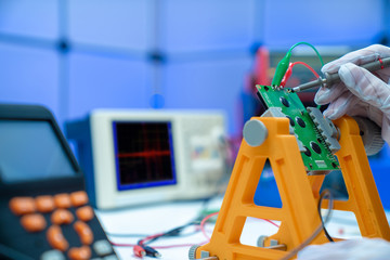 Canvas Print - Fixing electronics PCB board in service /  workbench with electronics measuring instruments