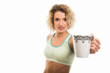 Wall Mural - Portrait of beautiful young fit girl offering coffee mug