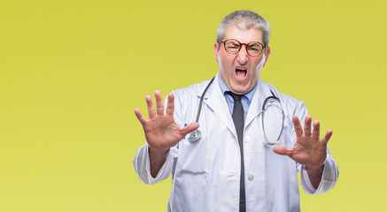 Sticker - Handsome senior doctor man over isolated background afraid and terrified with fear expression stop gesture with hands, shouting in shock. Panic concept.